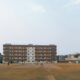 Cricket field with stadium lights and building