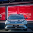 A sleek car is parked in front of a showroom