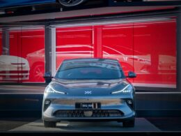 A sleek car is parked in front of a showroom