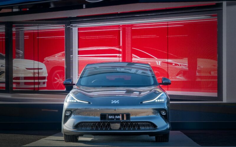 A sleek car is parked in front of a showroom