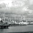 Industrial port with cranes under cloudy sky